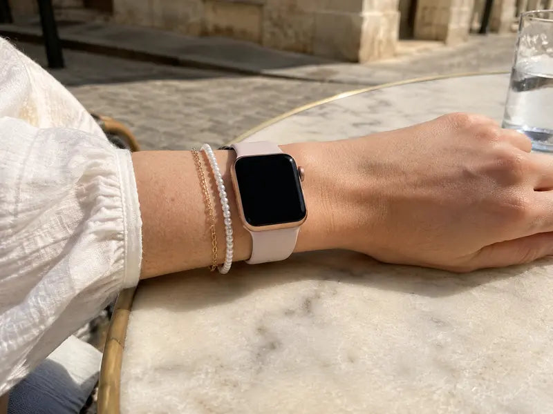 Model A wearing a feminine Apple Watch bracelet stack with coordinated metal and pearl details