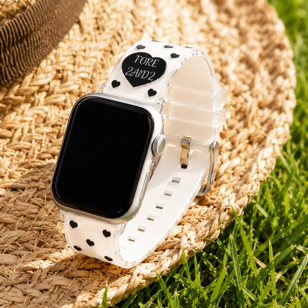Amour black heart TPU Apple Watch band styled on a straw hat in sunlit grass