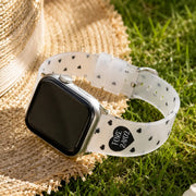 Amour clear TPU Apple Watch band with black hearts styled beside a straw hat