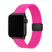 Fuchsia braided Apple Watch band with black case and black slider clasp on a white background