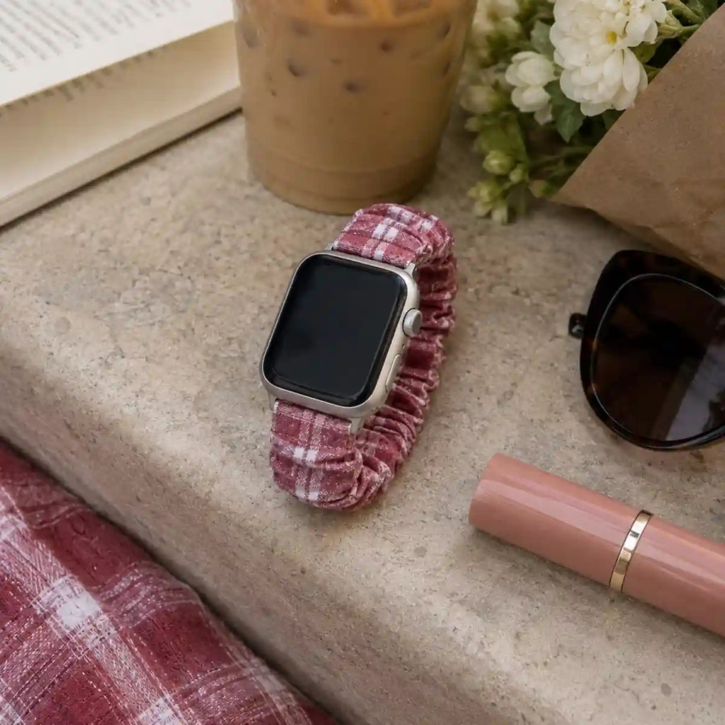 Élise burgundy gingham scrunchie Apple Watch band in a café-inspired flat lay with flowers and iced coffee.