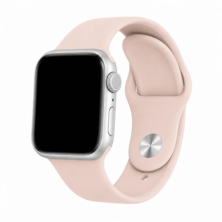 Blush pink silicone Apple Watch band with a light silver digital crown on a black-screen watch