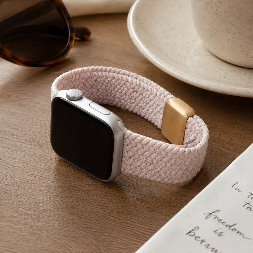 Margaux blush braided loop Apple Watch band in a coffee table flat lay