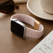 Margaux blush braided loop Apple Watch band in a coffee table flat lay