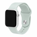 Soft mint silicone Apple Watch band with a silver-tone pin closure on a black-screen watch