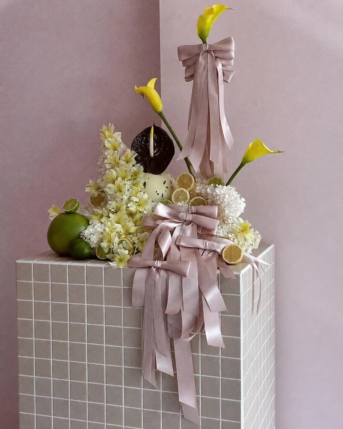 Pink satin bows, calla lilies and citrus in a CELI RAE editorial arrangement