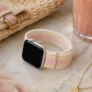 Rosalie pastel woven loop Apple Watch band displayed with a pink smoothie and woven accessories.