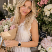 Rosalie pastel woven loop Apple Watch band worn with a romantic floral look at a flower shop.