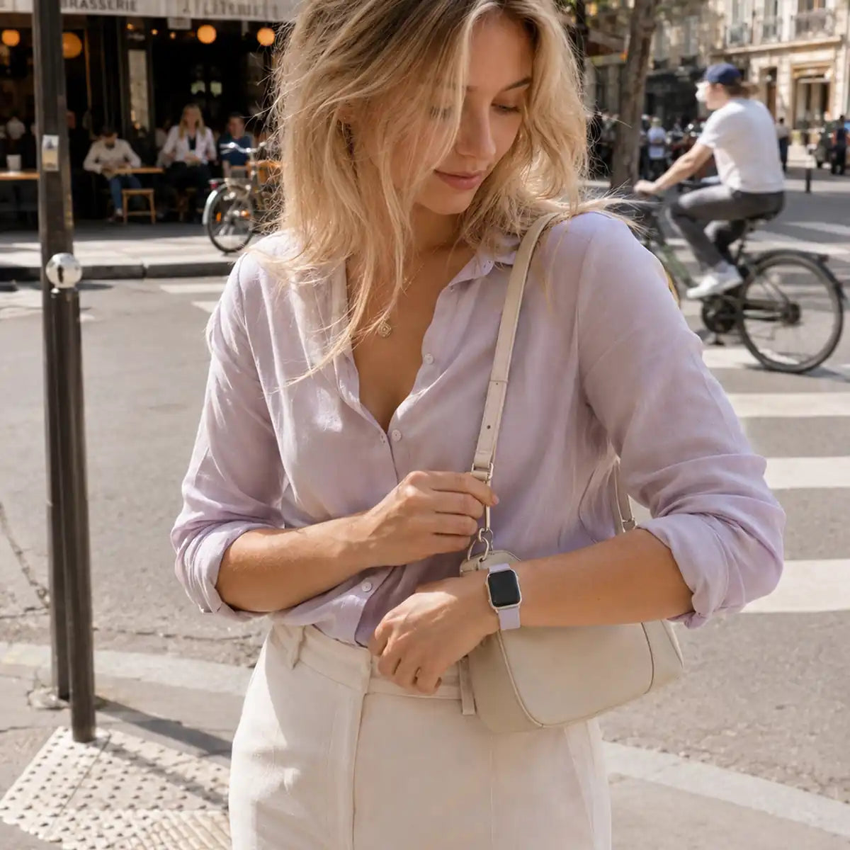 Violette lavender silicone Apple Watch band paired with a lilac shirt near a Paris café.