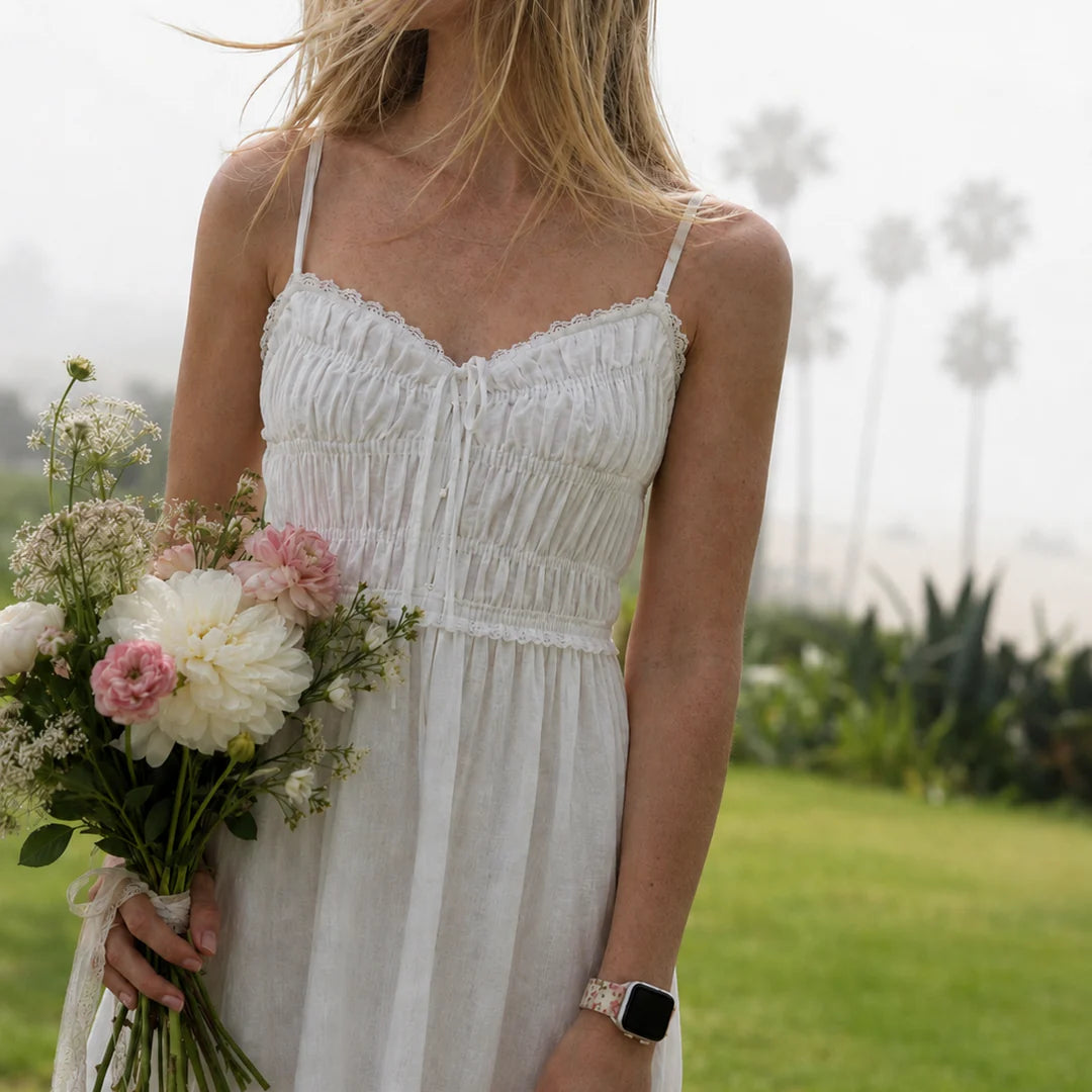 Model wearing the Elodie vintage floral Apple Watch band with a white summer dress